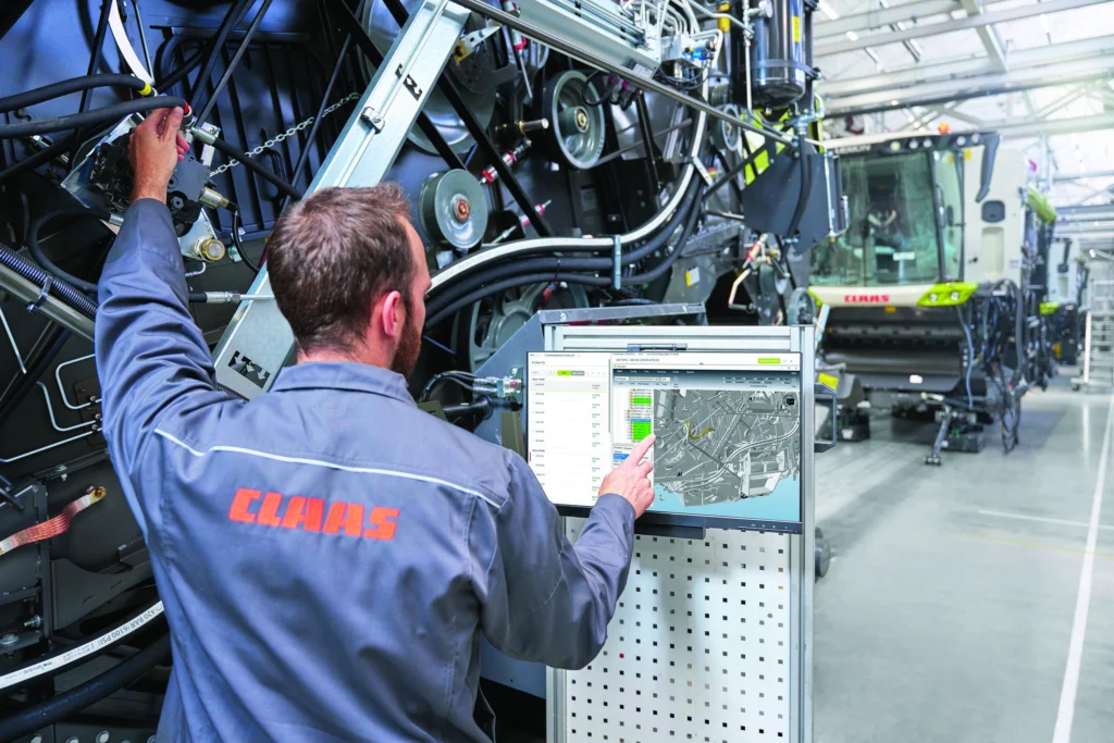 KI-gestützte Assistenz: Ein Claas-Mitarbeiter nutzt ein Werkerassistenzsystem,
um durch die Montage des Mähdreschers geführt zu
werden © Janosch Gruschczyk / Fraunhofer IEM